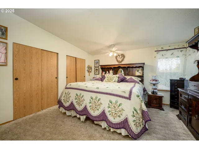 a bedroom with a bed mirror and a window