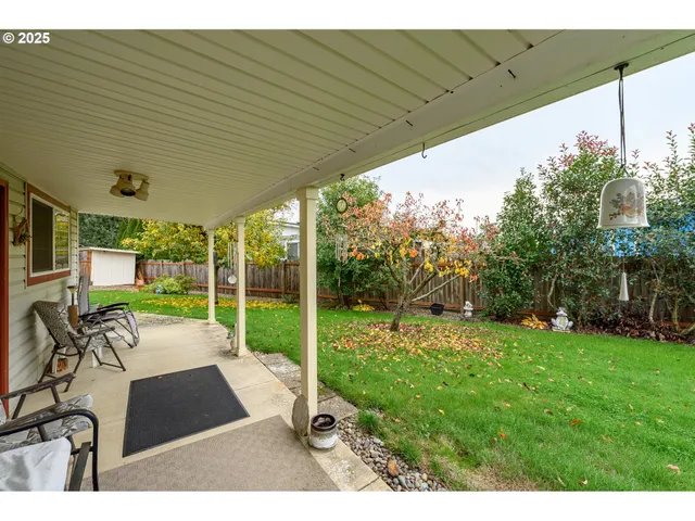 a view of backyard with potted plants and wooden fence