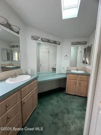 a bathroom with a double vanity sink a mirror and a bathtub