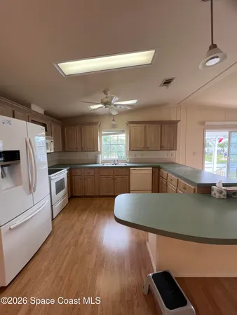 a kitchen with stainless steel appliances granite countertop a sink a stove top oven a counter space and cabinets