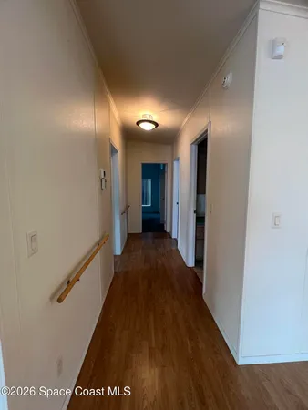 a view of a hallway with wooden floor