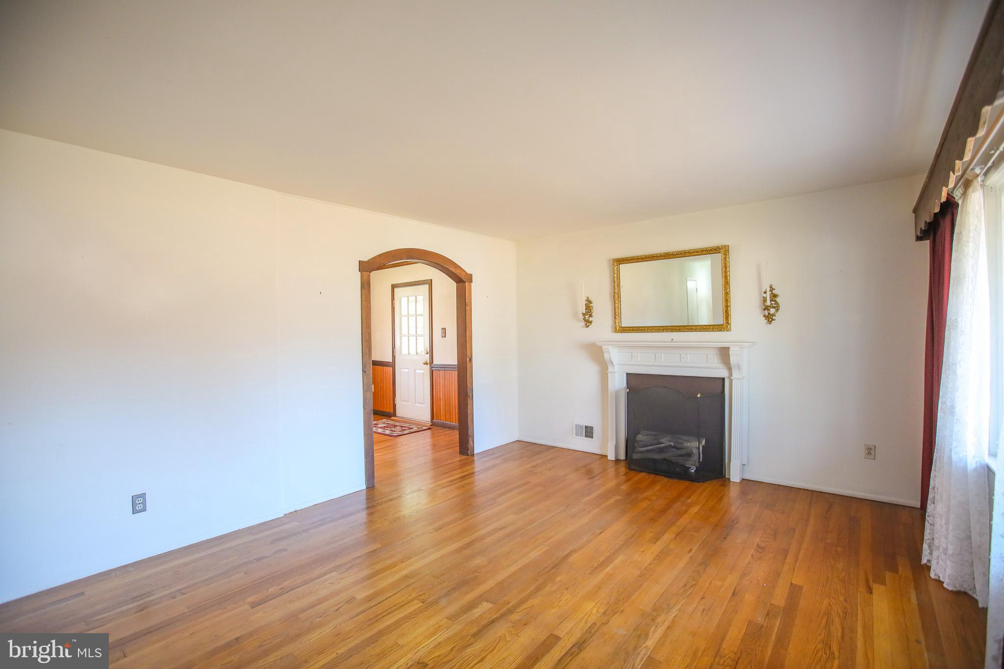 8815 Jandell Road Lorton, VA 22079 - Photo 3 of 27 an empty room with fireplace and wooden floor