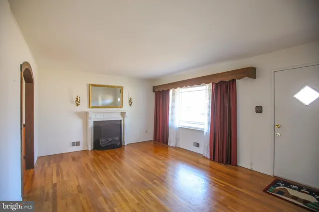 an empty room with windows and a fireplace