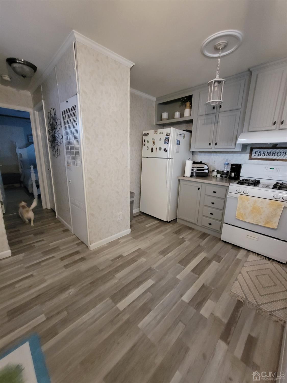 18 3rd Street Avenel, NJ 07001 - Photo 9 of 20 a kitchen with a refrigerator a stove top oven a counter space and wooden floor