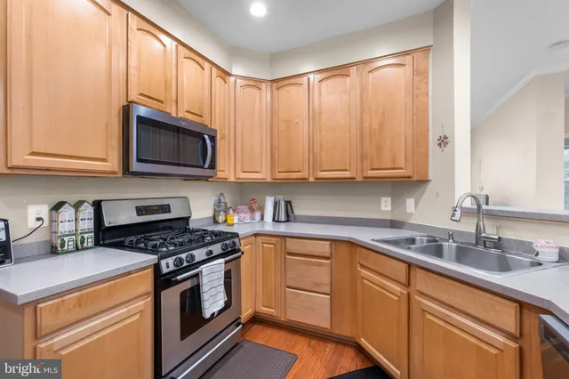 a kitchen with granite countertop white cabinets sink and stainless steel appliances