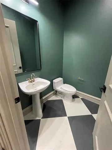 a bathroom with a sink toilet and mirror