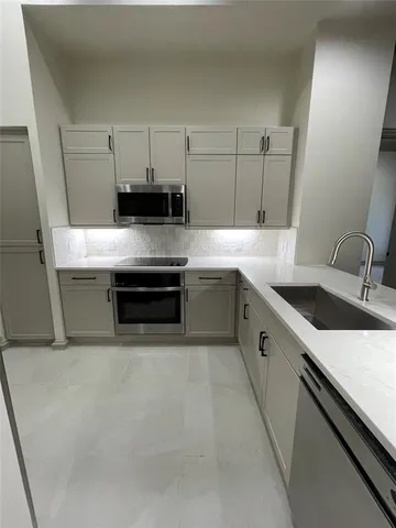a kitchen with stainless steel appliances granite countertop a sink and a stove