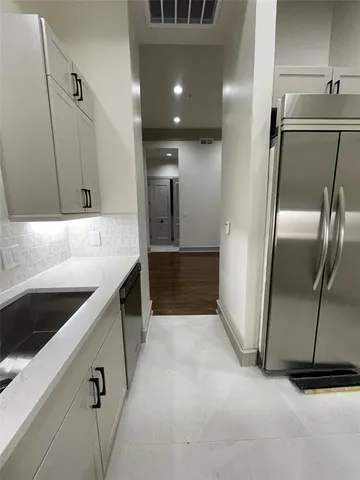 a kitchen with granite countertop a refrigerator and a sink
