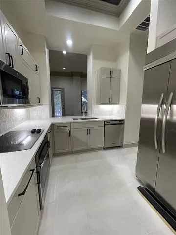 a large kitchen with a large counter top stainless steel appliances and cabinets
