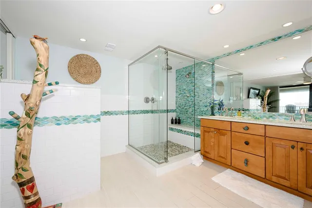 a bathroom with a granite countertop sink a mirror and a shower