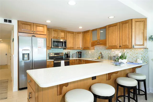 a kitchen with a refrigerator sink and cabinets