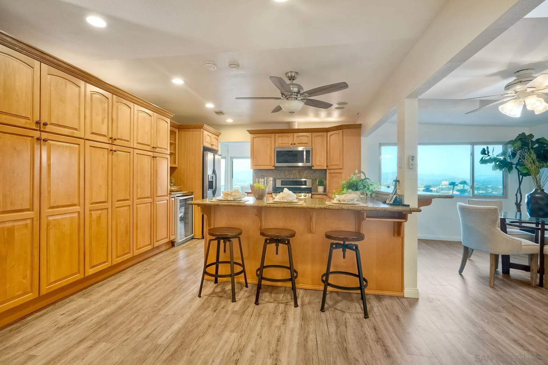 1605 Swallow Drive El Cajon, CA 92020 - Photo 11 of 39 a dining room with stainless steel appliances granite countertop a refrigerator a stove a sink with a dining table and chairs with wooden floor