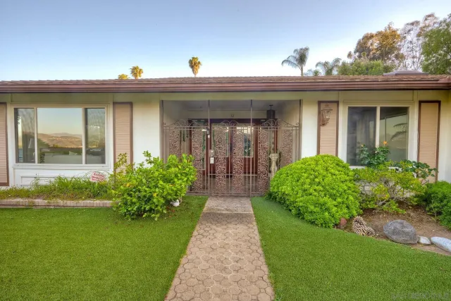 a view of a house with brick walls and a yard with plants