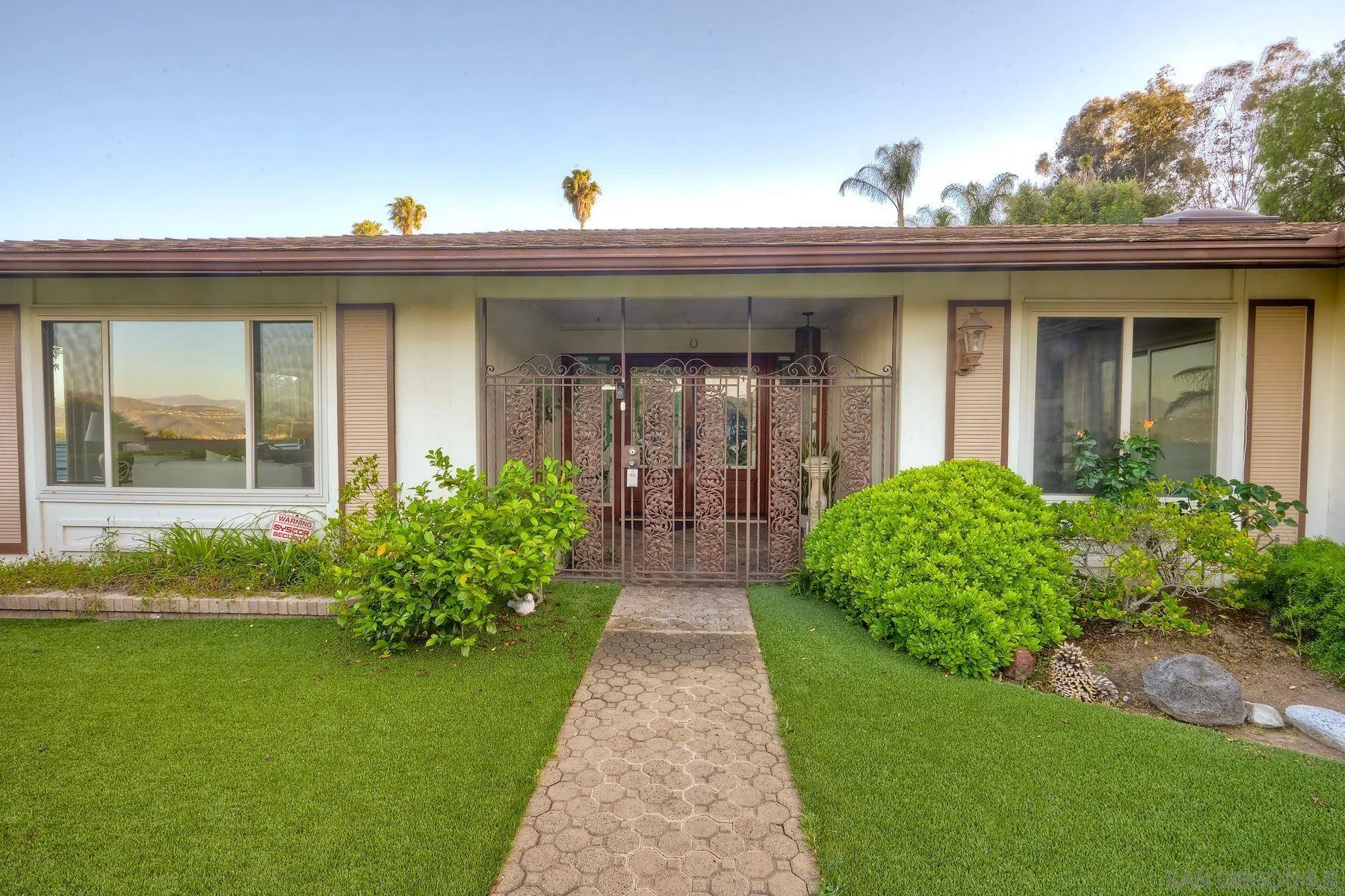 1605 Swallow Drive El Cajon, CA 92020 - Photo 2 of 39 a view of a house with brick walls and a yard with plants