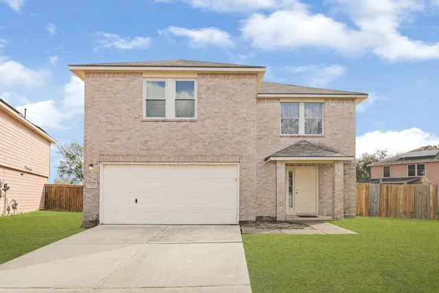 a front view of a house with a garden and yard