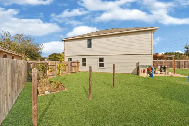 a view of backyard with wooden fence and a large tree