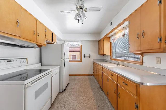 a kitchen with stainless steel appliances granite countertop a stove a refrigerator and a sink