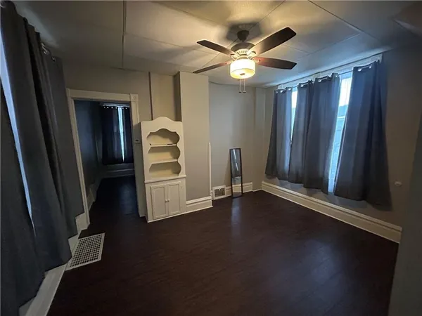 an empty room with wooden floor door and windows