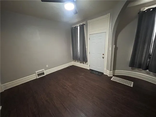 an empty room with wooden floor and window