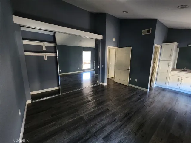 an empty room with wooden floor and closet