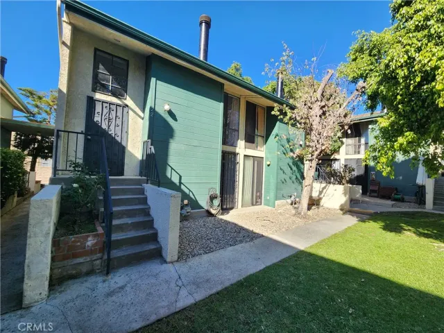 a view of a house with backyard and sitting area