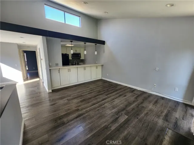 a view of a hallway with wooden floor and a living room