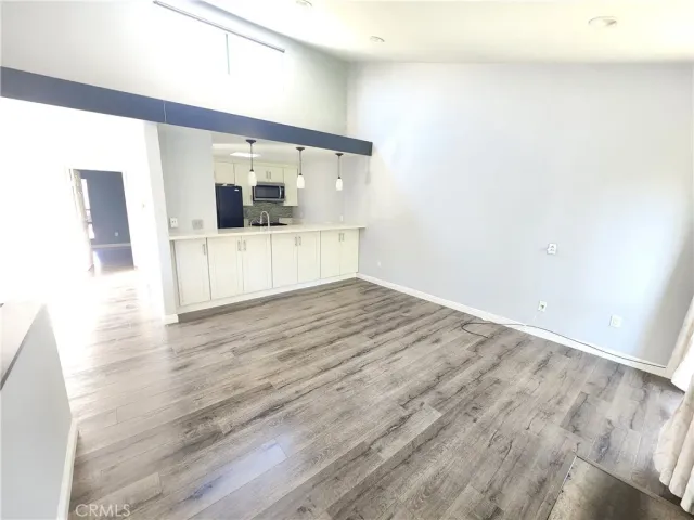 a view of a hallway with wooden floor and furniture