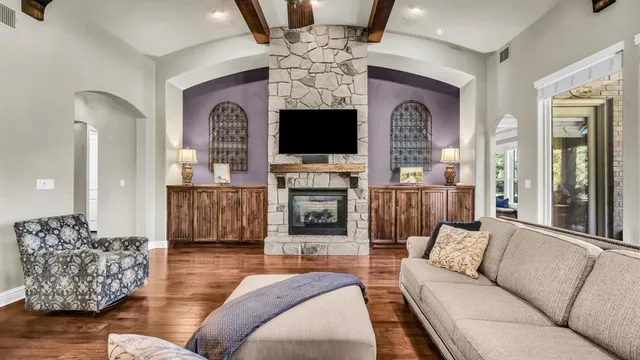 a living room with furniture a flat screen tv and a fireplace
