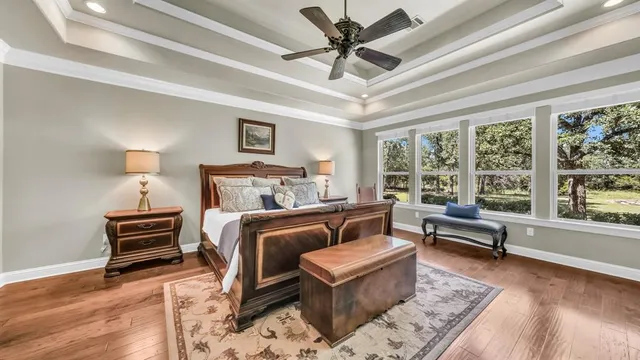 a bedroom with a bed wooden floor and a couch