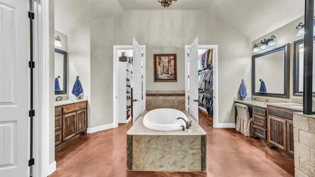 a bedroom with a large bed a flat tv screen and a dresser