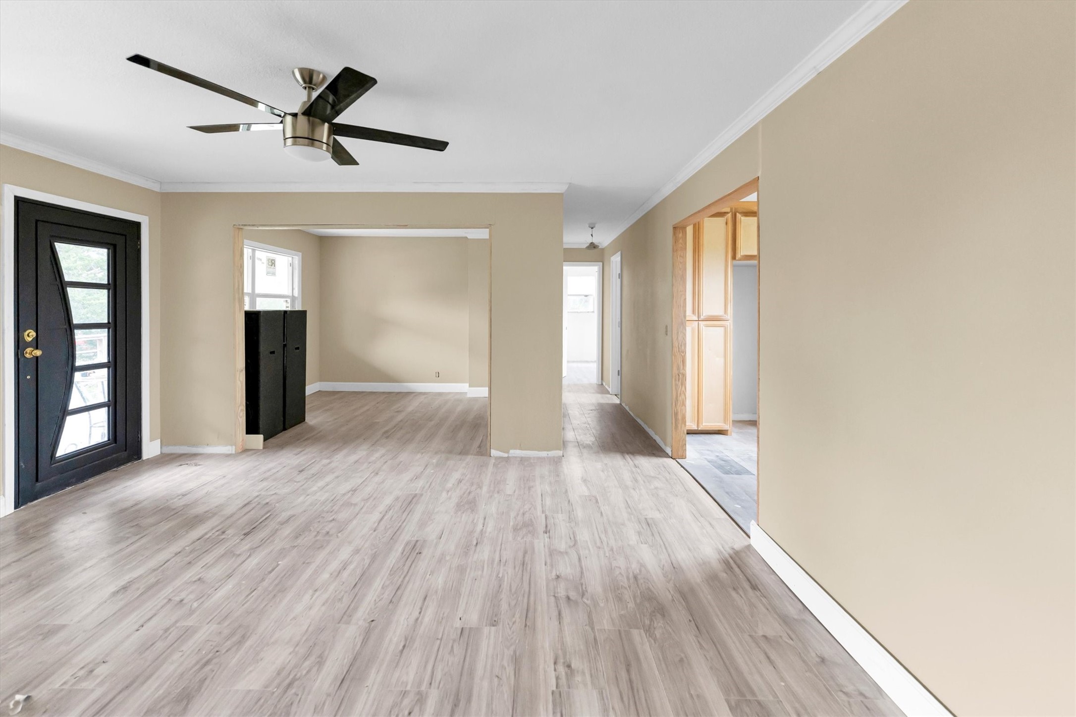 a view of empty room with wooden floor and ceiling fan
