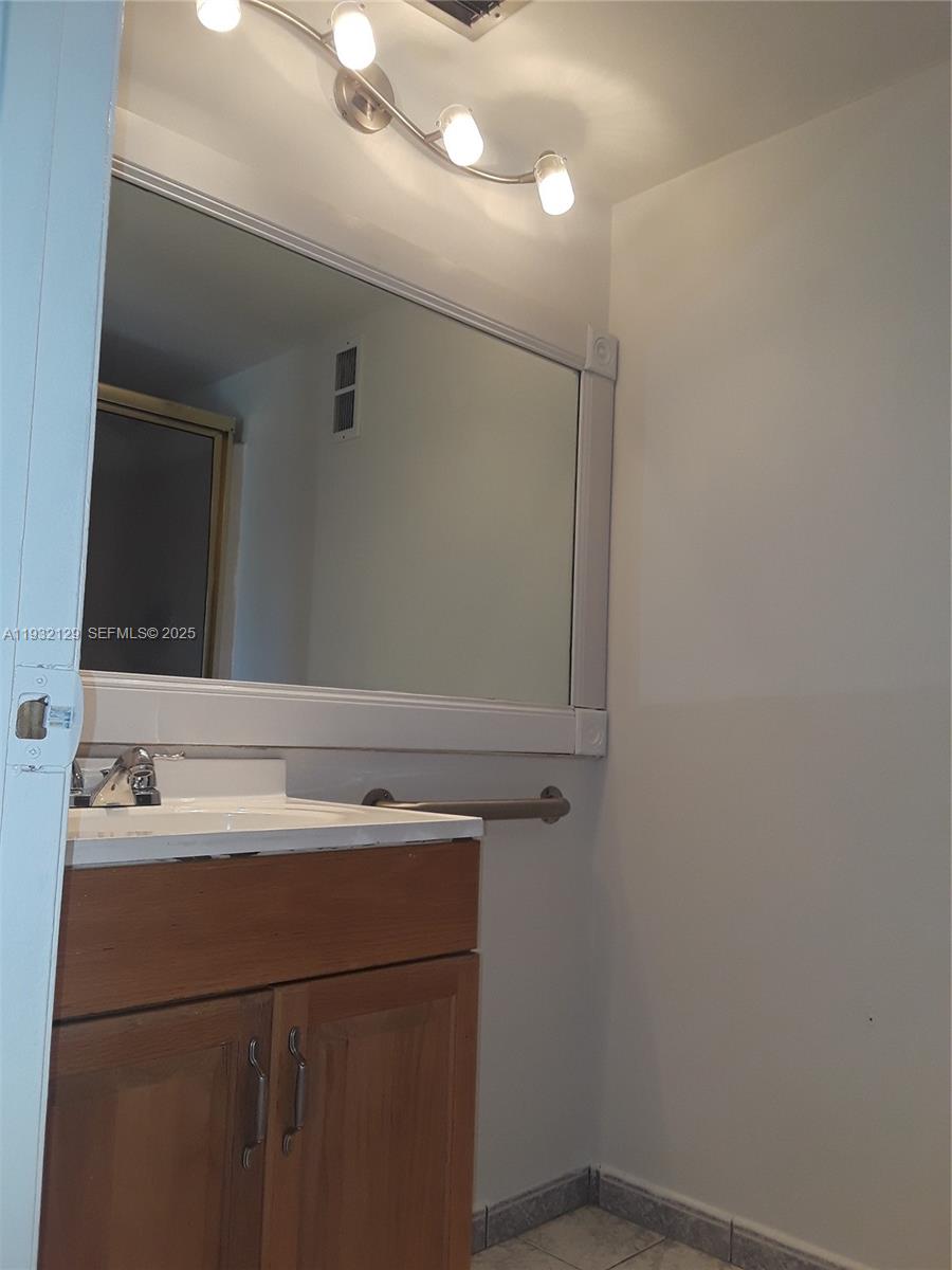 8700 Sherman Circle North, Unit 407 Miramar, FL 33025 - Photo 12 of 12 a bathroom with a sink and a mirror