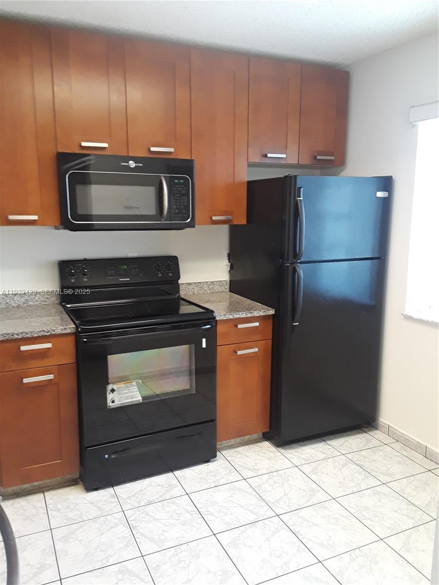 8700 Sherman Circle North, Unit 407 Miramar, FL 33025 - Photo 3 of 12 a kitchen with appliances and cabinets