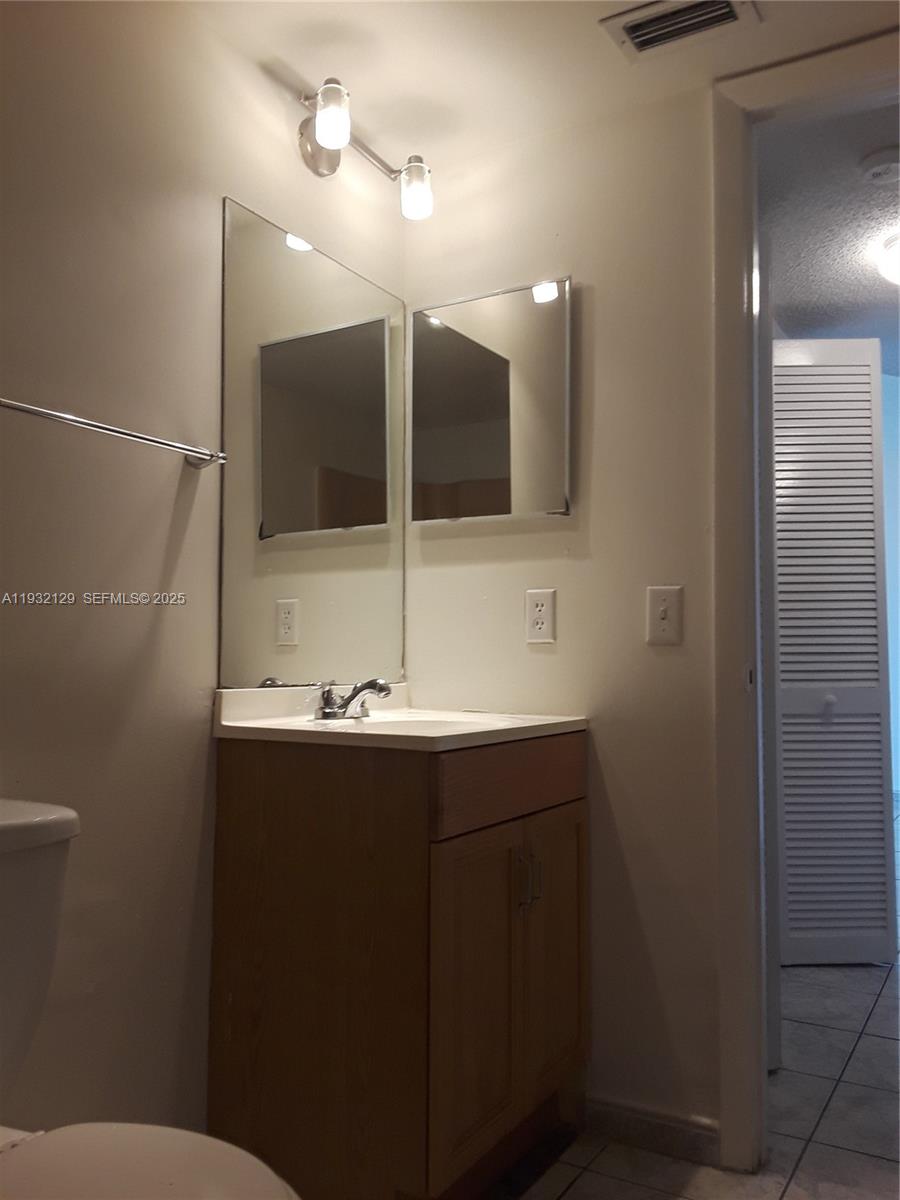 8700 Sherman Circle North, Unit 407 Miramar, FL 33025 - Photo 7 of 12 a bathroom with a sink and mirror