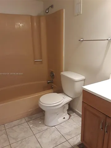 a white toilet sitting next to a bath tub