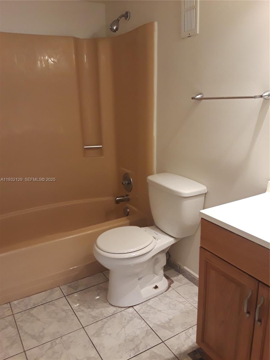 8700 Sherman Circle North, Unit 407 Miramar, FL 33025 - Photo 8 of 12 a white toilet sitting next to a bath tub