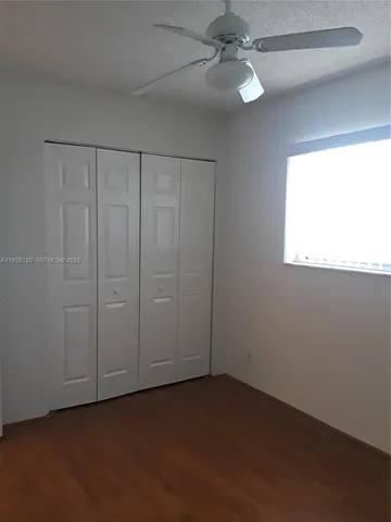 an empty room with fan and windows
