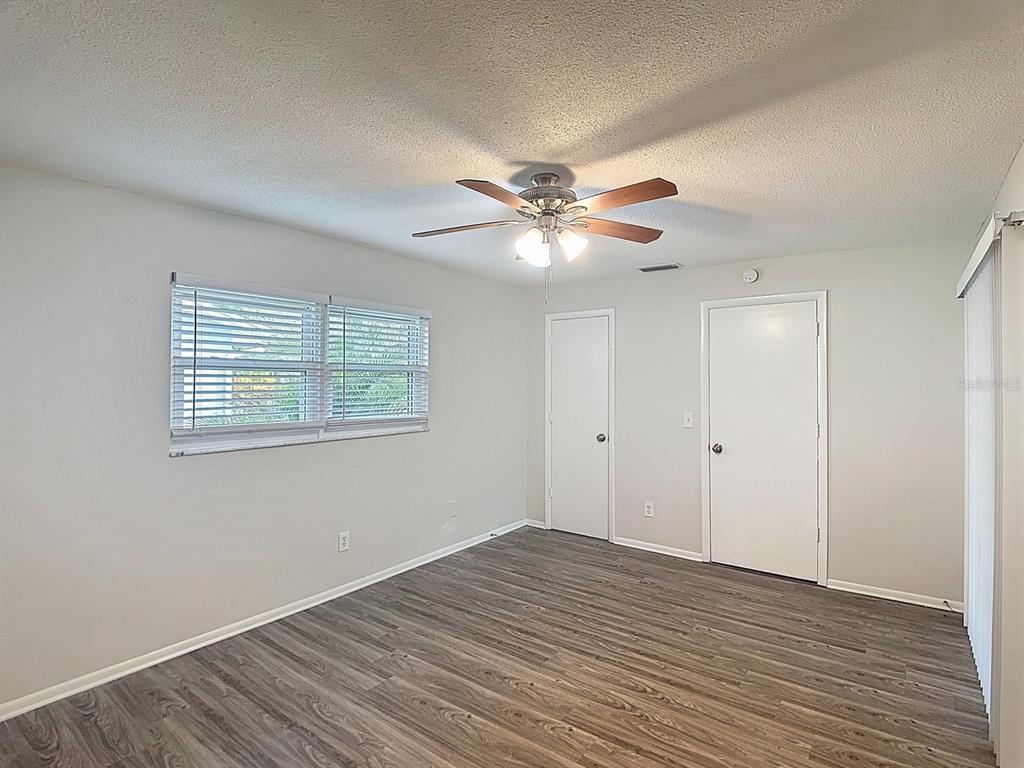 11320 Currie Lane Largo, FL 33774 - Photo 13 of 40 wooden floor in an empty room with a window