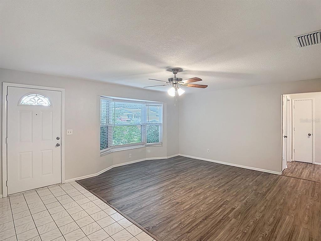 11320 Currie Lane Largo, FL 33774 - Photo 14 of 40 a view of an empty room with glass door and chandelier fan