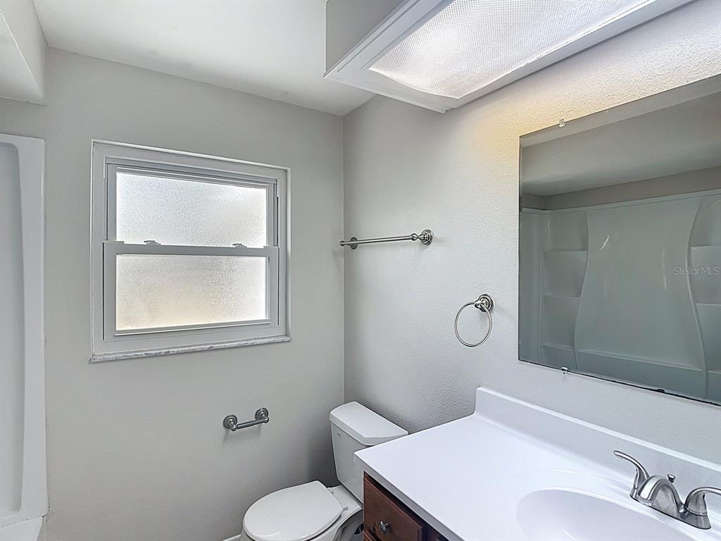 11320 Currie Lane Largo, FL 33774 - Photo 18 of 40 a bathroom with a toilet a sink and mirror