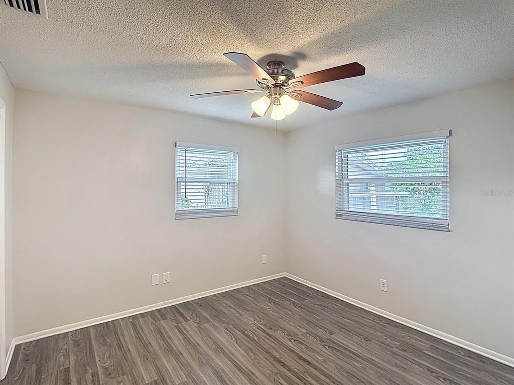 11320 Currie Lane Largo, FL 33774 - Photo 21 of 40 a view of an empty room with wooden floor and a window