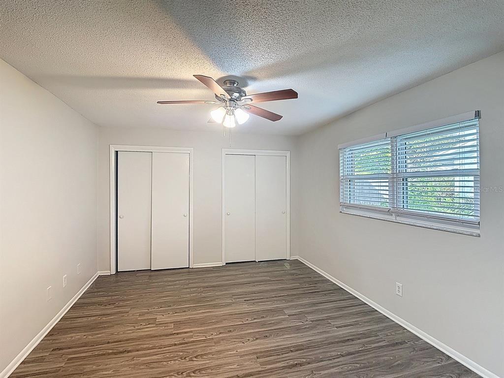11320 Currie Lane Largo, FL 33774 - Photo 22 of 40 a view of an empty room with wooden floor and a ceiling fan