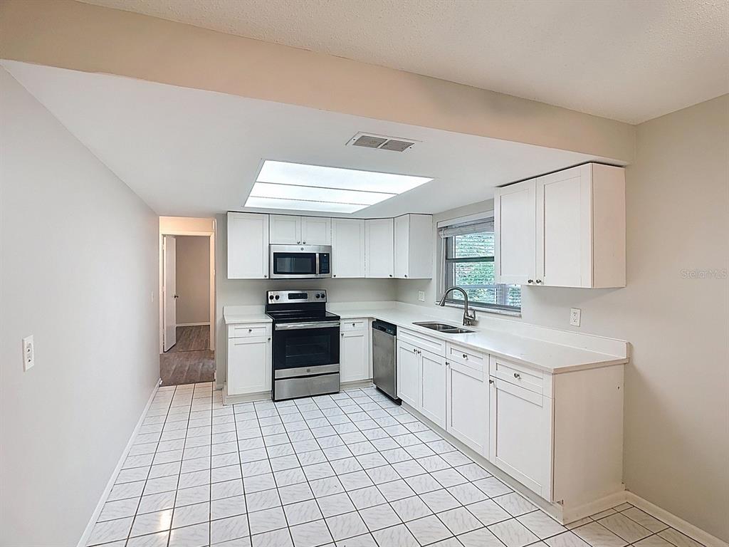11320 Currie Lane Largo, FL 33774 - Photo 6 of 40 a kitchen with stainless steel appliances a sink and cabinets