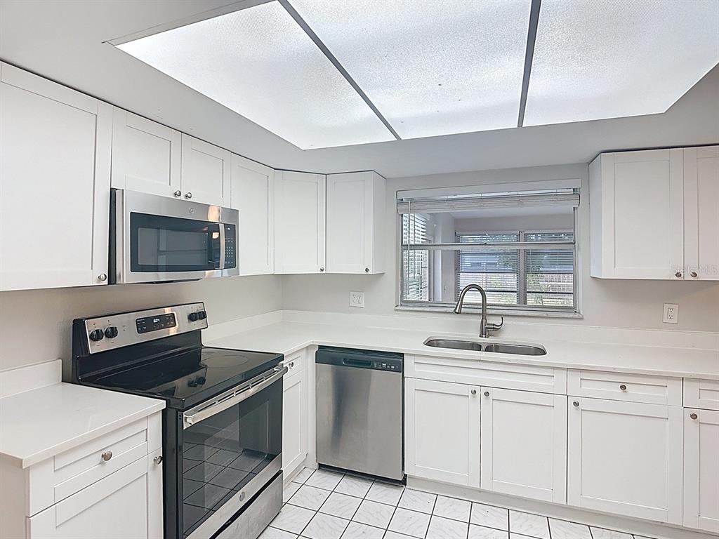 11320 Currie Lane Largo, FL 33774 - Photo 7 of 40 a kitchen with white cabinets appliances and a sink