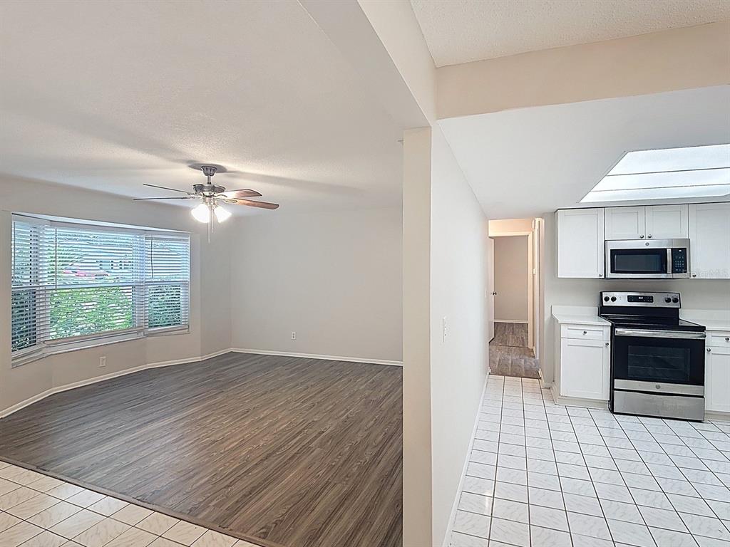 11320 Currie Lane Largo, FL 33774 - Photo 9 of 40 a view of a kitchen from the hallway with a stove wooden floor and chandelier