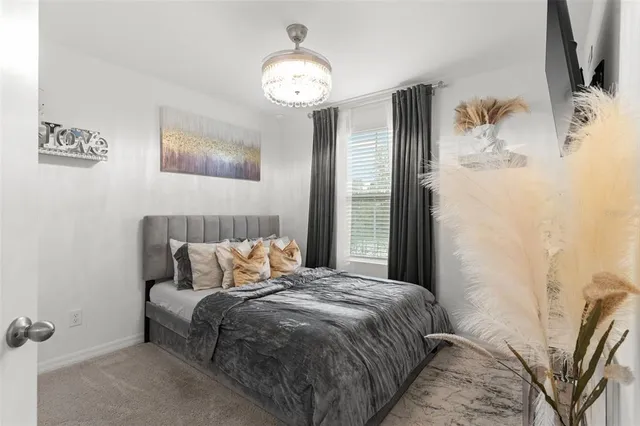 a bedroom with a bed and a chandelier