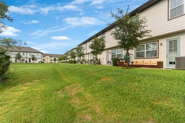 a view of a house with a big yard and large trees