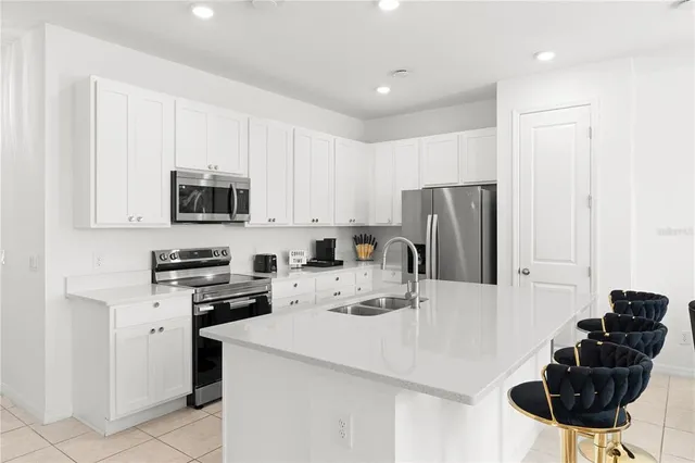 a kitchen with stainless steel appliances a stove refrigerator sink and cabinets