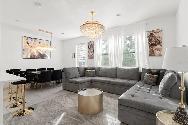 a living room with furniture a table and a large window