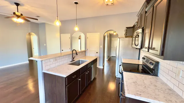 a kitchen with stainless steel appliances granite countertop a sink a stove and a refrigerator